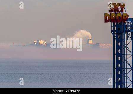 Southend on Sea, Essex, Großbritannien. Februar 2021, 3rd. HMM Le Havre wird am späten Nachmittag am Southend on Sea Seafront Park an der Themse Mündung vorbei gesehen und verschwindet in Nebel, nachdem er DP World London Gateway Port verlassen hat. Das Containerschiff der Algeciras-Klasse ist eines der größten jemals gebauten Schiffe, das im August 2020 in Dienst gestellt wurde und fast 24000 Container befördern kann. Es bedient die Route Fernost-Europa 3. Das Vereinigte Königreich bewirbt sich um den Beitritt zum umfassenden und progressiven Abkommen über die Transpazifische Partnerschaft (CPTPP), zu dem auch fernöstliche Länder gehören, die von riesigen Schiffen wie diesem bedient werden Stockfoto