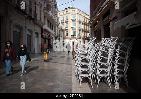 Malaga, Spanien. Februar 2021, 3rd. Stühle, die auf einem leeren 'Uncibay'-Platz inmitten der teilweisen Sperrung durch eine Coronavirus-Pandemie gestapelt wurden. Kredit: Jesus Merida/SOPA Images/ZUMA Wire/Alamy Live Nachrichten Stockfoto