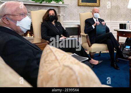 Präsident Joe Biden, rechts, trägt eine Schutzmaske beim Treffen mit US-Vizepräsident Kamala Harris, Mitte, und demokratischen Senatoren, um den amerikanischen Rettungsplan im Oval Office des Weißen Hauses in Washington am Mittwoch, 3. Februar 2021 zu diskutieren. Quelle: Stefani Reynolds / Pool via CNP - weltweite Nutzung Stockfoto