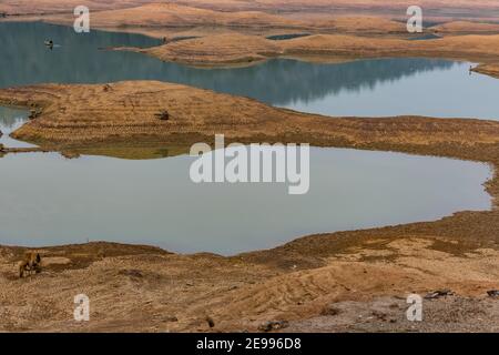 Ein ländlicher indischer kleiner See haben sehr weniger Wasser mit viel Grün Bergwald Hintergrund. Stockfoto