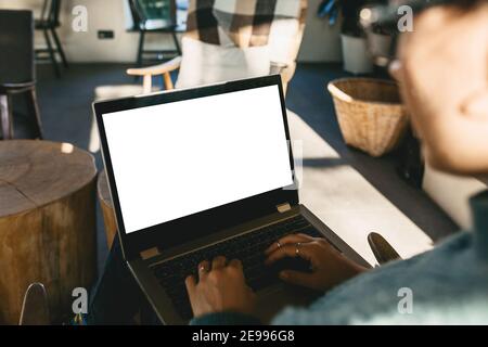 Mädchen zu Hause verwendet Laptop mockup. Moderne Technik im Alltag. Leere weiße Bildschirmanzeige für Text oder Vorlage. Stockfoto