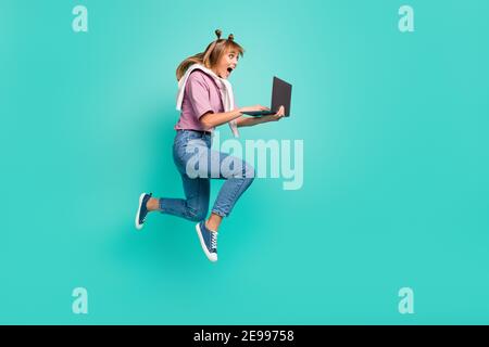 Volle Größe Profil Seite Foto von jungen schockiert überrascht Mädchen halten Laptop sieht Verkauf isoliert auf türkisfarbenem Hintergrund Stockfoto