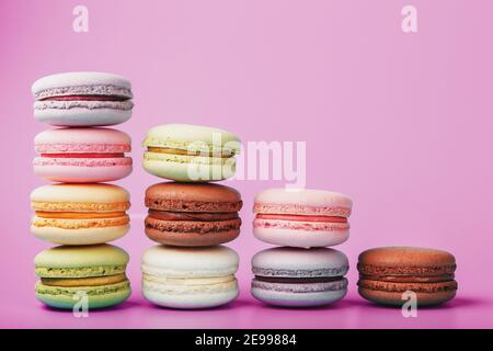 Bunte französische Makkaroni-Kekse sind in einer Pyramide auf dem Hintergrund angeordnet. Draufsicht, freier Platz Stockfoto