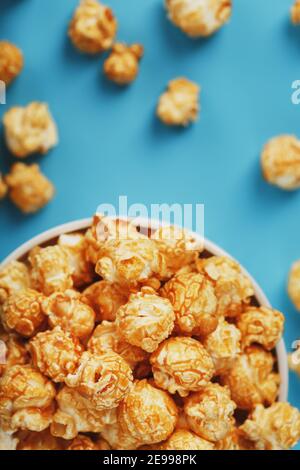 Karamell Popcorn in einer Tasse auf blauem Hintergrund, Draufsicht. Süßes, frisches und geschmackvolles Dessert Stockfoto