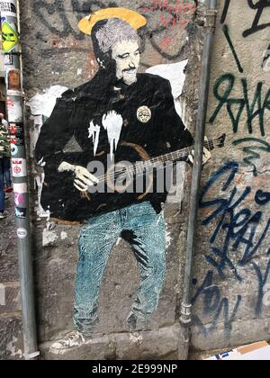 Graffiti eines Rockmusikers mit Gitarre auf einer Straße in Neapel, Italien. Stockfoto