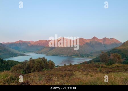 Blick auf die fünf Schwestern von Kintail bei Sonnenuntergang von Loch Duich, Schottland. Stockfoto