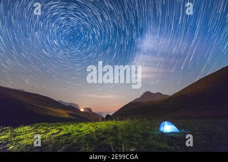 Ein Touristenzelt in der Nacht am Rand unter dem Sternenhimmel. Stockfoto