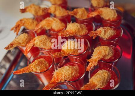 Individuelle Cocktail Shrimp Shot Gläser mit leckeren hausgemachten Tartar würzig Sauce mit Petersilienblatt auf weißem Teller auf dem Tisch dekoriert Matte für Chris Stockfoto