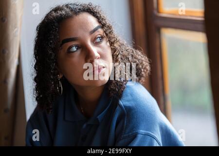 Schöne gemischte Rasse afrikanisch amerikanisch Mädchen Teenager weiblich junge Frau Traurig deprimiert oder besorgt aus dem Fenster zu schauen Stockfoto