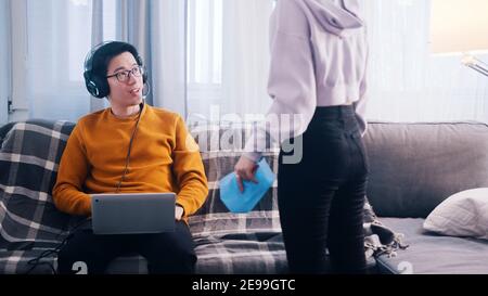 Junger Mann spielt Spiele auf seinem Laptop und ignoriert seine Freundin. Frau sucht Aufmerksamkeit. Hochwertige Fotos Stockfoto