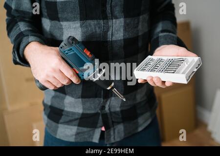 Nahaufnahme eines Mannes, der einen Schraubendreher und seine Hand hält Zubehör Stockfoto