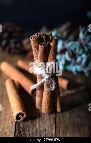 Auswahl an ätherischen Ölen mit Nelke und Zimtstangen auf dem Holzhintergrund. Stockfoto