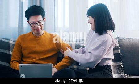 Junge Frau lenkt ihren Freund von der Arbeit ab. Nachteile von Remote-Arbeit. Hochwertige Fotos Stockfoto