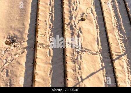 Bahngleise bei Sonnenuntergang unter dem Schnee Stockfoto