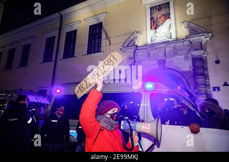 Krakau, Kleinpolen, Polen. Februar 2021, 1st. Ein Protestler, der während der Demonstrationen durch ein Megaphon im katholischen Gebäude der städtischen Kurie spricht.nach dem am 27th. Januar in Kraft getretenden Urteil des polnischen Verfassungsgerichts zur Umsetzung eines der restriktivsten Anti-Abtreibungsgesetze in Europa gingen Hunderte von Polen in allen größeren Städten auf die Straße. Die Proteste wurden vom Frauenstreik organisiert. Kredit: Filip Radwanski/SOPA Images/ZUMA Wire/Alamy Live Nachrichten Stockfoto