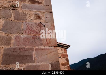 Eine Sonnenuhr auf der Seite einer Kirche in La Gariga. Die Sonnenuhr besteht aus dem Blut eines Stiers. Stockfoto