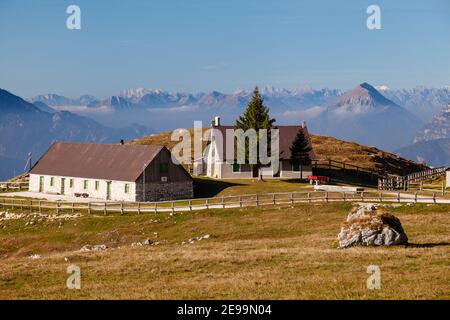 Herbstansicht der Bergfarm auf Planina Pecol mit dem Berg Amariana und anderen Gipfeln im Hintergrund. Stockfoto