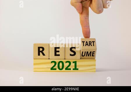 2021 Symbol für Wiederaufnahme und Neustart. Geschäftsmann dreht einen Würfel und ändert das Wort '2021 Lebenslauf' zu '2021 Neustart'. Schöner weißer Hintergrund. Unternehmen und Stockfoto