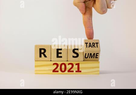 2021 Symbol für Wiederaufnahme und Neustart. Geschäftsmann dreht einen Würfel und ändert das Wort '2021 Lebenslauf' zu '2021 Neustart'. Schöner weißer Hintergrund. Unternehmen und Stockfoto