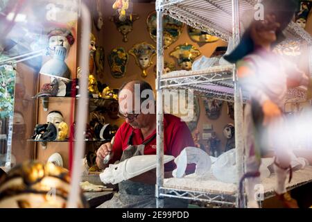 Venedig, Italien - 2. februar 2021: Handwerker machen venedig Karnevalsmasken bei der Arbeit in seinem Geschäft. Venezianische Masken Atelier und Werkstatt Stockfoto