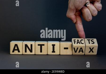 Anti-Facts- oder Anti-vax-Symbol. Der Arzt dreht einen Würfel, ändert die Worte „Anti-vax“ in „Anti-Fakten“. Schöner grauer Hintergrund. Speicherplatz kopieren. Business, Medizin Stockfoto