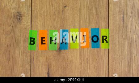 Verhaltenssymbol. Konzept Wort "Verhalten" auf farbigen Papieren auf einem schönen Holzhintergrund, kopieren Raum. Business, Psychologie und Verhaltenskonzept. Stockfoto