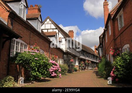 Fachwerkhäuser in Schwarz & Weiß & Backstein in Shakespeares Country Malt Mill Lane Alcester Warwickshire, Großbritannien. Mit floralen Blüten im Hochsommer. Stockfoto