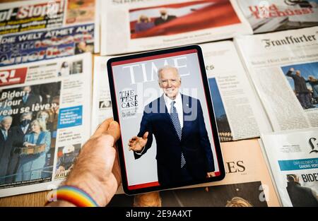 Paris, Frankreich - Jan 21, 2021: Mann hält digitale Tablette mit Time Magazin Cover mit Joe Biden und Stapel mit International Newspapers Schlagzeile mit Joe Biden und First Lady, der neu gewählte US-Präsident vereidigt als der 46th Präsident der Vereinigten Staaten
