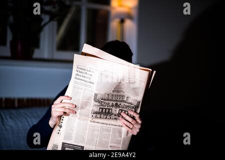 Paris, Frankreich - 21. Jan 2021: Frau, die in der abendlichen Financial Times Zeitung mit Trump liest, verlässt das Weiße Haus - als der neu gewählte US-Präsident, der als Präsident der Vereinigten Staaten von 46th eingeschworen wurde Stockfoto