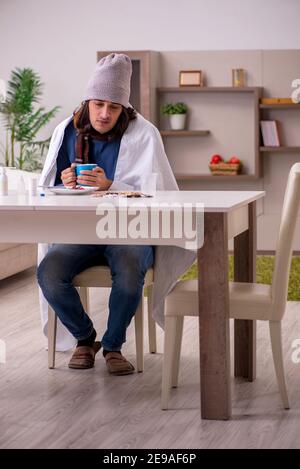 Junger Mann, der sich zu Hause schlecht fühlt Stockfoto