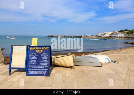 Schild für Bootsfahrten und Ausflüge in Swanage Bay, Swanage, und Blick auf Swanage Pier, Isle of Purbeck an der Jurassic Coast, Dorset, Südwest-England Stockfoto