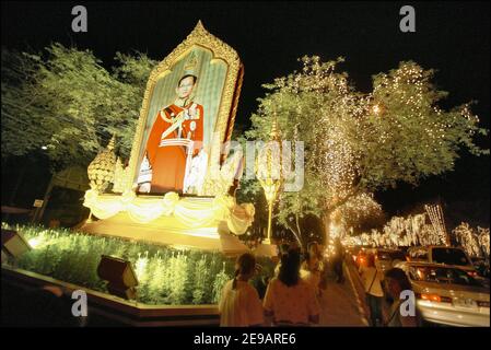 Tausende von gelben T-Shirted Thais (die Farbe des Tages Geburt ihres Königs) beobachten den Beginn eines Feuerwerks in der Nähe des Großen Palasts in Bangkok, 09. Juni 2006. Hunderttausende Thais nahmen an einer Kerzenlichtmahnwache Teil, um dem thailändischen König Bhumibol Adulyadej, dem am längsten regierenden Monarchen der Welt, am 60th. Jahrestag seiner Herrschaft Tribut zu zollen, als am 9. Juni 2006 ein Feuerwerk über den vergoldeten Türmen historischer Paläste und Tempel ausbrach. Foto von Patrick Durand/ABACAPRESS.COM Stockfoto