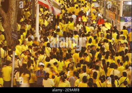 Tausende von gelben T-Shirted Thais (die Farbe des Tages Geburt ihres Königs) beobachten den Beginn eines Feuerwerks in der Nähe des Großen Palasts in Bangkok, 09. Juni 2006. Hunderttausende Thais nahmen an einer Kerzenlichtmahnwache Teil, um dem thailändischen König Bhumibol Adulyadej, dem am längsten regierenden Monarchen der Welt, am 60th. Jahrestag seiner Herrschaft Tribut zu zollen, als am 9. Juni 2006 ein Feuerwerk über den vergoldeten Türmen historischer Paläste und Tempel ausbrach. Foto von Patrick Durand/ABACAPRESS.COM Stockfoto