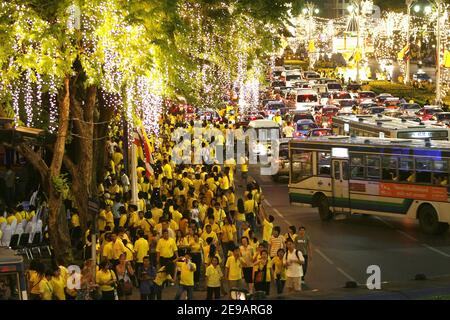 Tausende von gelben T-Shirted Thais (die Farbe des Tages Geburt ihres Königs) beobachten den Beginn eines Feuerwerks in der Nähe des Großen Palasts in Bangkok, 09. Juni 2006. Hunderttausende Thais nahmen an einer Kerzenlichtmahnwache Teil, um dem thailändischen König Bhumibol Adulyadej, dem am längsten regierenden Monarchen der Welt, am 60th. Jahrestag seiner Herrschaft Tribut zu zollen, als am 9. Juni 2006 ein Feuerwerk über den vergoldeten Türmen historischer Paläste und Tempel ausbrach. Foto von Patrick Durand/ABACAPRESS.COM Stockfoto