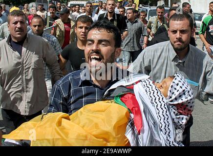 Palästinensische Männer tragen die Leiche des achtjährigen Maher al-Mughrabi, der bei einem israelischen Sir-Angriff im nördlichen Gazastreifen während seiner Beerdigung in Gaza-Stadt, Palästina, am 13. Juni 2006 getötet wurde. Neun Zivilisten, darunter zwei Kinder, wurden getötet und 42 verletzt, als eine von einem israelischen Flugzeug abgefeuerte Rakete als Zuschauer am Tatort eines israelischen Angriffs auf ein Auto mit drei Mitgliedern der militanten Gruppe des Islamischen Dschihad antraf. Foto von Mohamed Atta/ABACAPRESS.COM Stockfoto