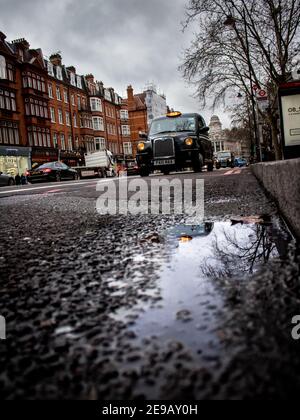 LONDON, VEREINIGTES KÖNIGREICH - Mar 11, 2018: Ein typisches Londoner Taxi, das die Stadt bereist. Mit einem Hintergrund regen, dass es noch mehr London macht Stockfoto