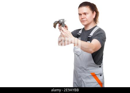 Männlicher Arbeiter in Uniform des arbeitenden Kfz-Mechanikers hält Bremse Der Schuh in den Händen misst die Asbestgröße des Autoersatzteils Bremsbelag mit Bremssattelwerkzeug isolieren Stockfoto