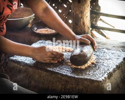 HIRIWADUNNA, SRI LANKA - 10. März 2019: Weibliche Hände bereiten Kokosnuss-Curry-Sauce in der ländlichen Küche zu. Öko-Dorf Hiriwadunna. Stockfoto