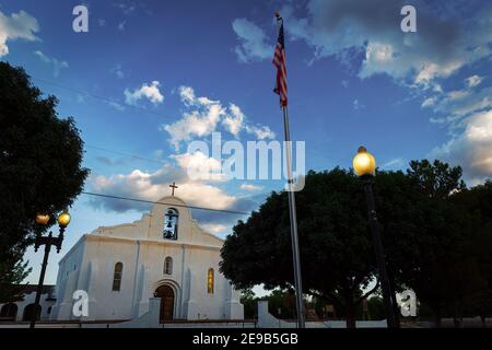 Eine amerikanische Flagge fliegt eine e; vening an der San Elizaario Mission in San Elizaario, Texas und Teil des El Paso Mission Trail. Stockfoto