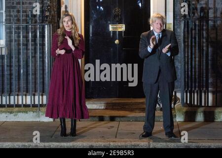 03. Februar 2021. London, Großbritannien. Der britische Premierminister Boris Johnson und seine Partnerin Carrie Symonds klatschen vor der Haustür der Downing Street 10 zu Ehren von Captain Tom Moore. Johnson hat die Bevölkerung Großbritanniens ermutigt, an einem öffentlichen Klatsch später an diesem Abend teilzunehmen, in Anerkennung des berühmten Health Service Charity Fund-Raiser Captain Tom, der am Dienstag starb. Foto von Ray Tang. Stockfoto