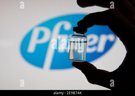 OXFORD, Großbritannien - Februar 2020: Eine kovidierte Impfstoffflasche vor dem pfizer-Logo Stockfoto