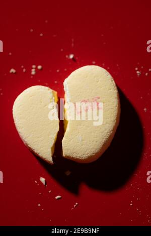 Ein zerbrochenes Candy-Gespräch-Herz mit 'Liebe' aufgedruckt Stockfoto