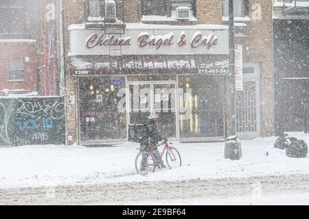 New York City, NY USA Fahrradlieferer im Schnee vor Chelsea Bagel und Cafe in der 14th Street Stockfoto