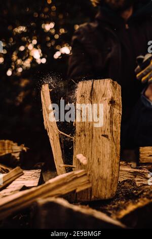 Holzhacken für Brennholz in Aktion und Nahaufnahme mit Partikel fliegen Stockfoto