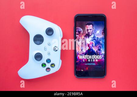 Calgary, Alberta. Kanada. Februar 3 2021. Eine Xbox-Fernbedienung mit Blick auf ein iPhone und einem Legionsspiel mit Watch Dogs. Stockfoto