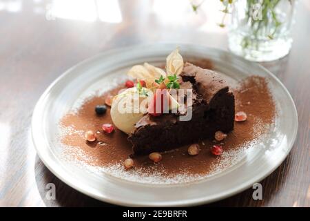 Schokoladenkuchen mit Eis Dessert auf Holztisch Stockfoto