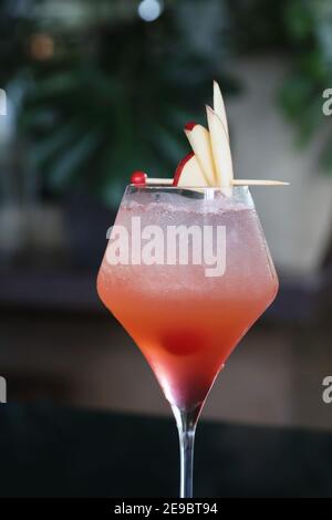 Rosafarbenes Cocktailglas mit Eis an der Theke Stockfoto
