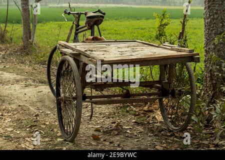 Viele alte und rostige Eisen- und Holzwagen auf dem Dorfstraße Stockfoto