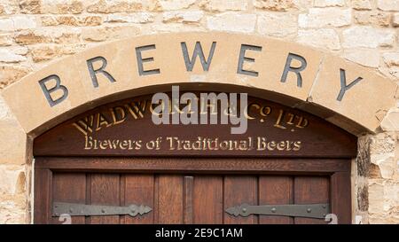 BURFORD, OXFORDSHIRE, Großbritannien - 31. OKTOBER 2009: Geschnitztes Schild über dem Eingang zur ehemaligen Wadworth Brewery und jetzt ein Ferienhaus Stockfoto