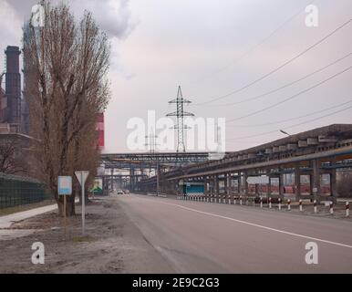 Eine Straße auf einem großen Industriegelände. Rohrleitungen, Stromleitungen. Stockfoto